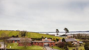 A rural setting with a large brick building, a small house, and a field.
