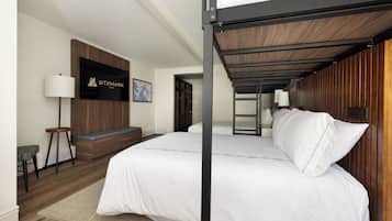 Ein modernes Hotelzimmer mit einem Etagenbett, einem an der Wand befestigten Fernseher, einer Bank und einer Holzwandverkleidung.