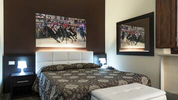 Una camera da letto con un letto grande, due comodini con lampade, un piano di appoggio e uno specchio fissato alla parete.