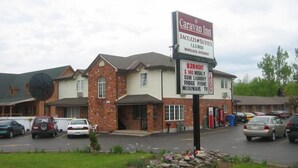 A Caravan Inn with a sign advertising Jacuzzi suites, 1-2-3 beds, and wireless internet. - Caravan Inn Motel (Niagara Falls)