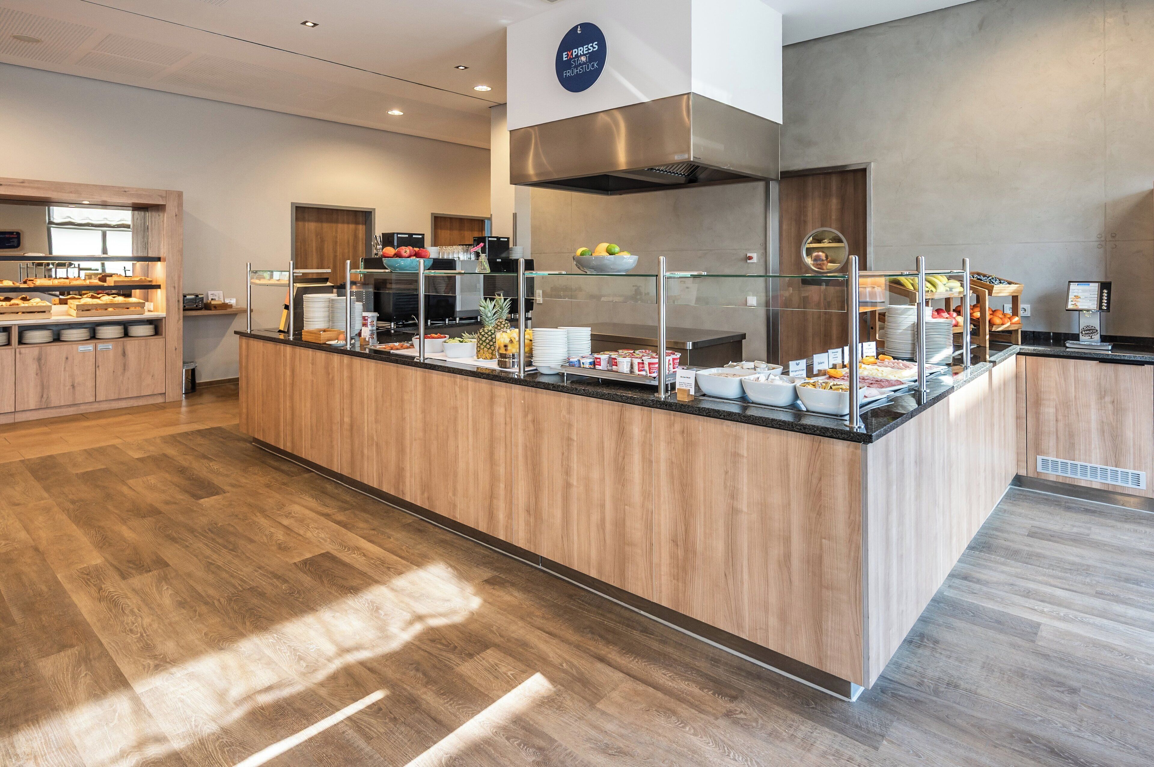 Una barra de desayuno moderna con diversas opciones de comida y una máquina de café.