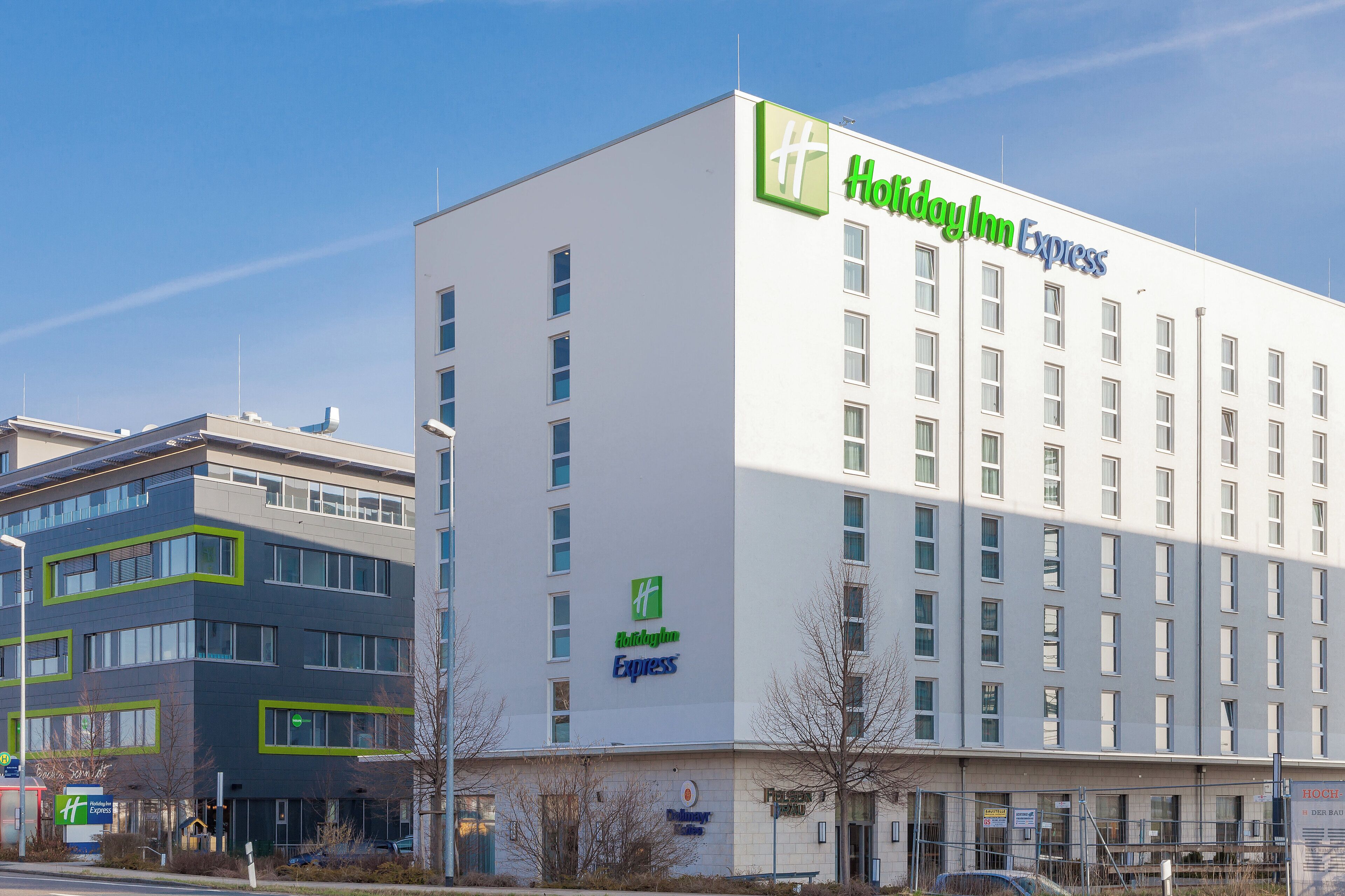 A Holiday Inn Express hotel with a modern facade, multiple windows, and a visible entrance.