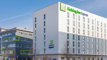 A Holiday Inn Express hotel with a modern facade, multiple windows, and a visible entrance.