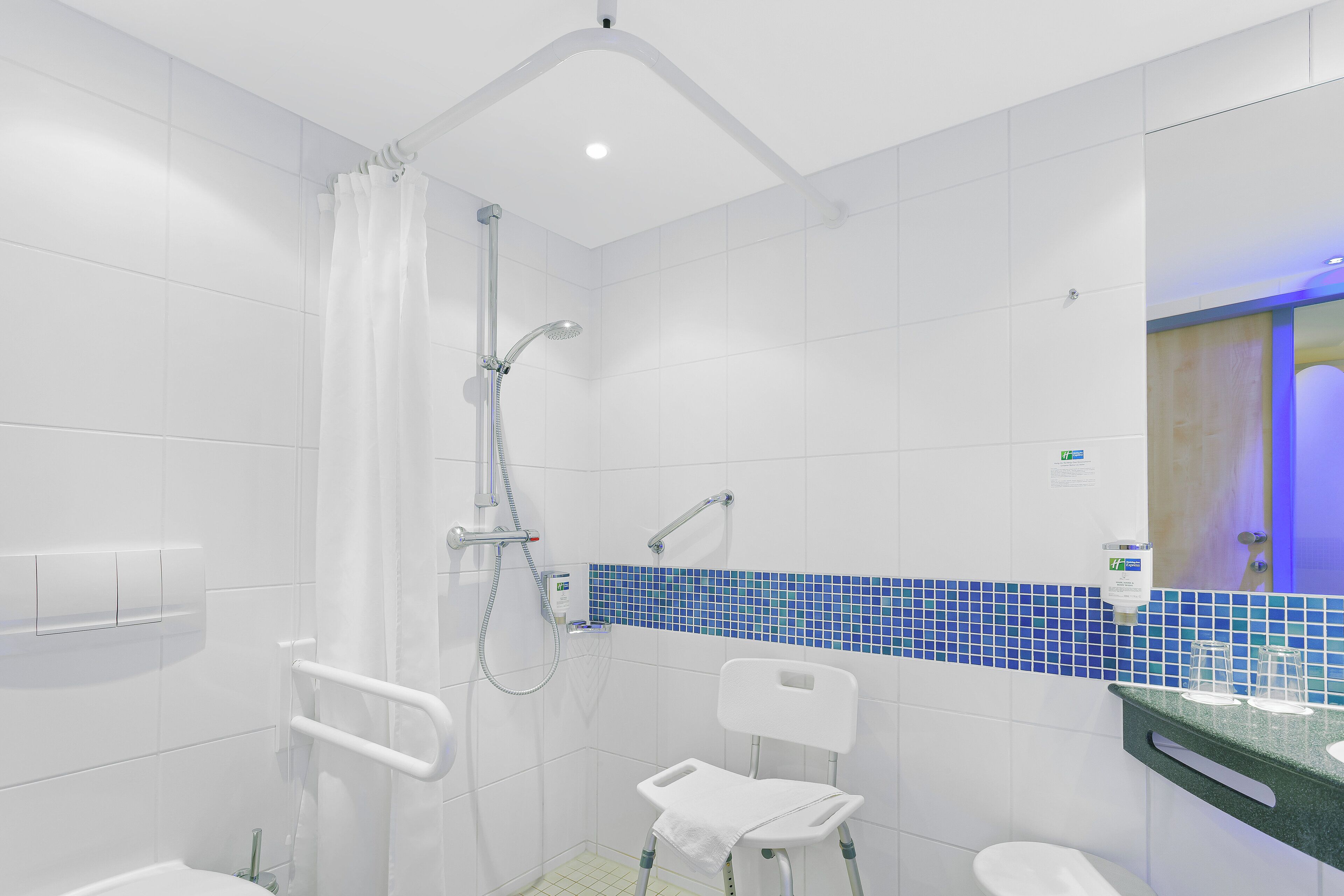 A modern bathroom with a shower, a toilet, and a sink.