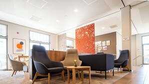 A modern lobby with comfortable seating, a decorative partition, and a sign indicating the location of the WC. - Holiday Inn Express Nuernberg-Schwabach by IHG (Schwabach)