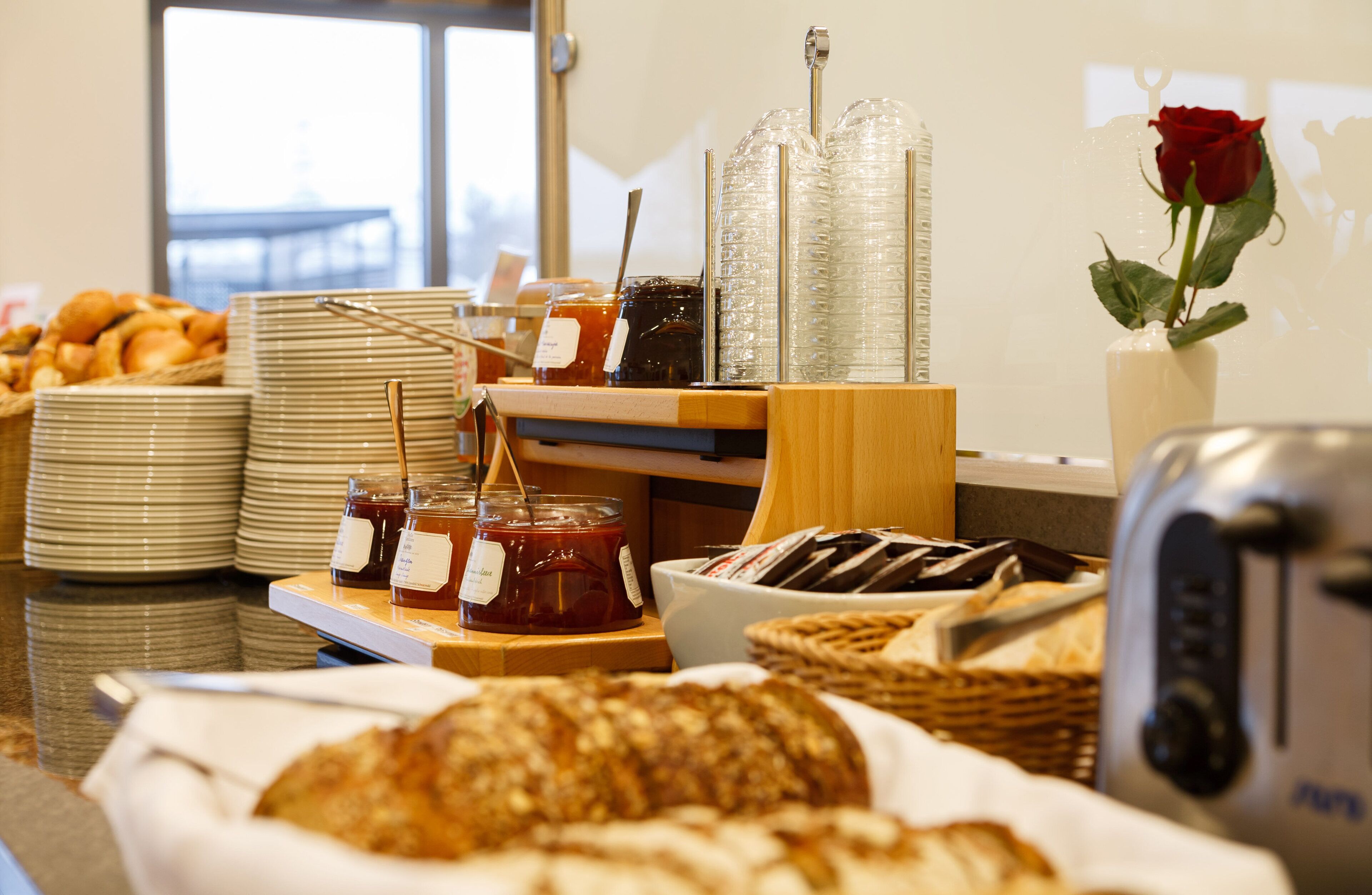 Un bufé de desayuno con diversas opciones de comida, incluyendo bollería, pan y salsas.