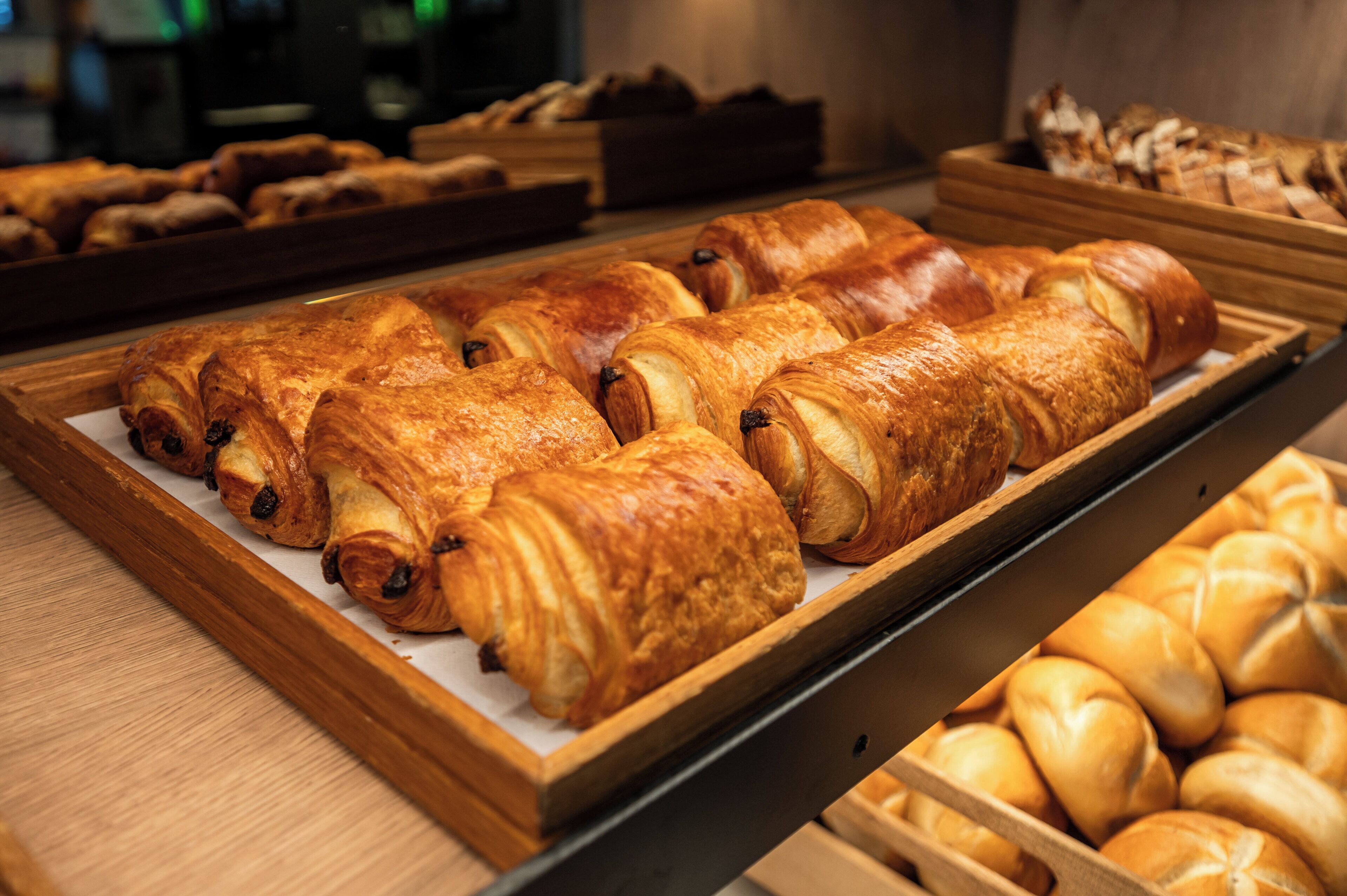 Una vetrina di panetteria con diversi tipi di pane e dolci.