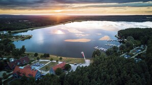 An aerial view of a lakeside area with a marina, boats, and buildings with red roofs. - Holiday Inn Express Nuernberg-Schwabach by IHG (Schwabach)