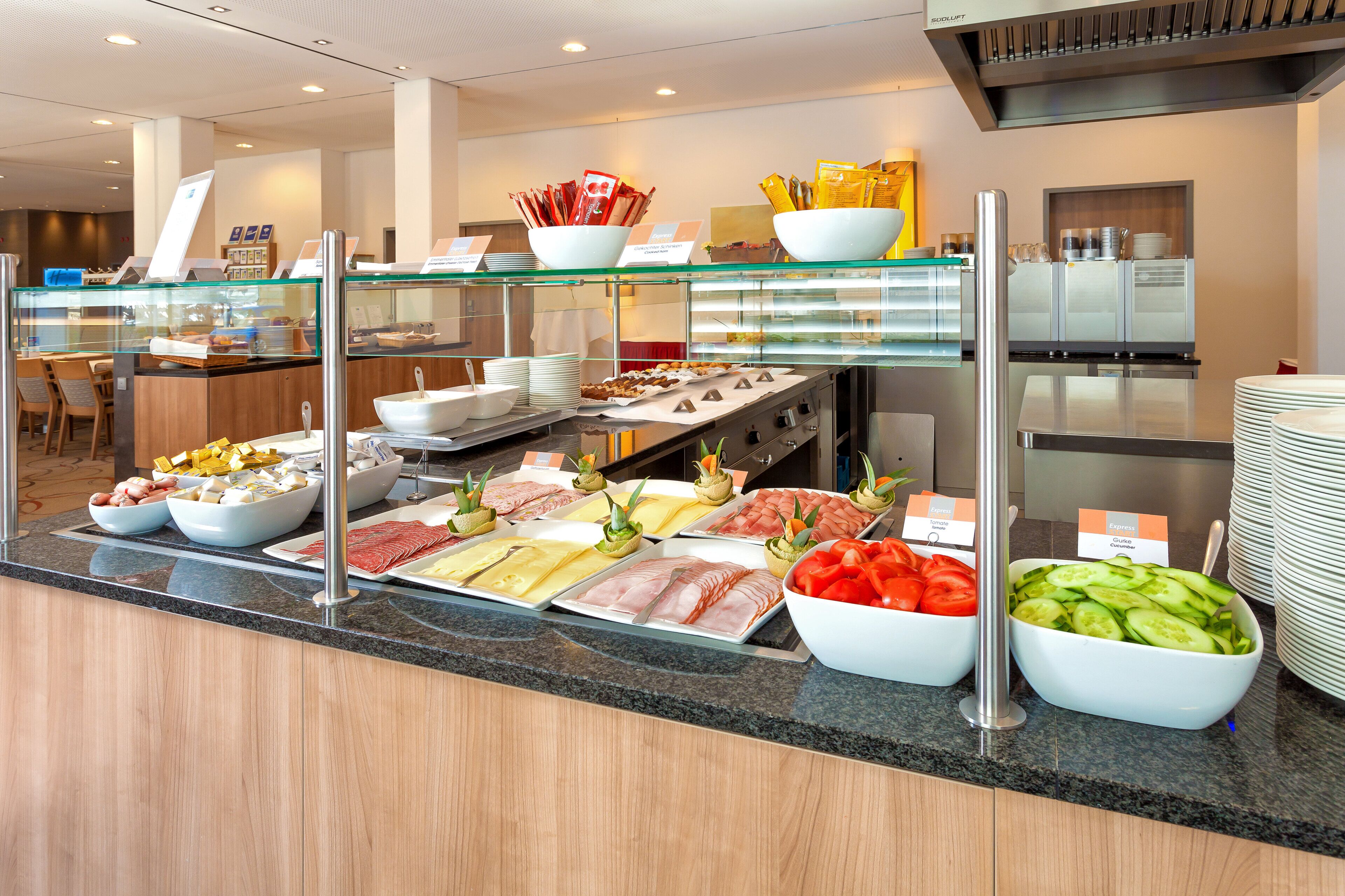 A buffet with various food options including meats, cheeses, and vegetables.