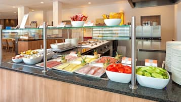 A buffet with various food options including meats, cheeses, and vegetables.