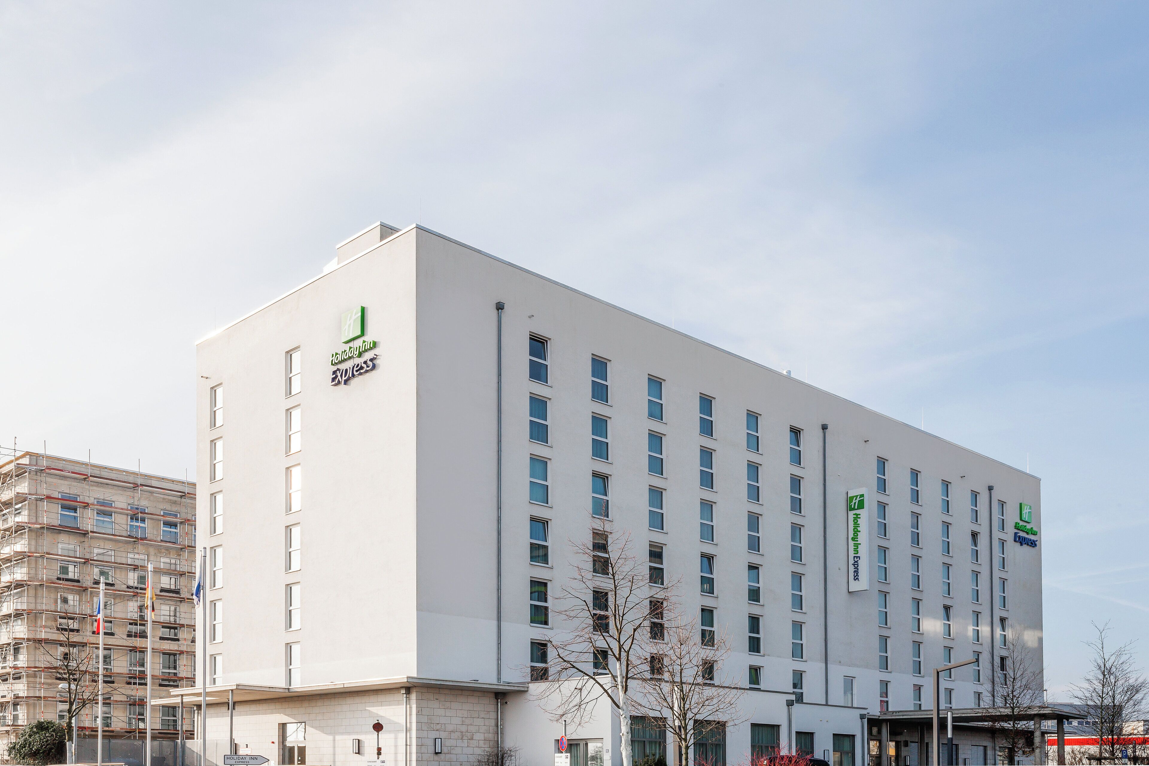 A multi-story Holiday Inn Express building with a modern facade, large windows, and a flat roof.