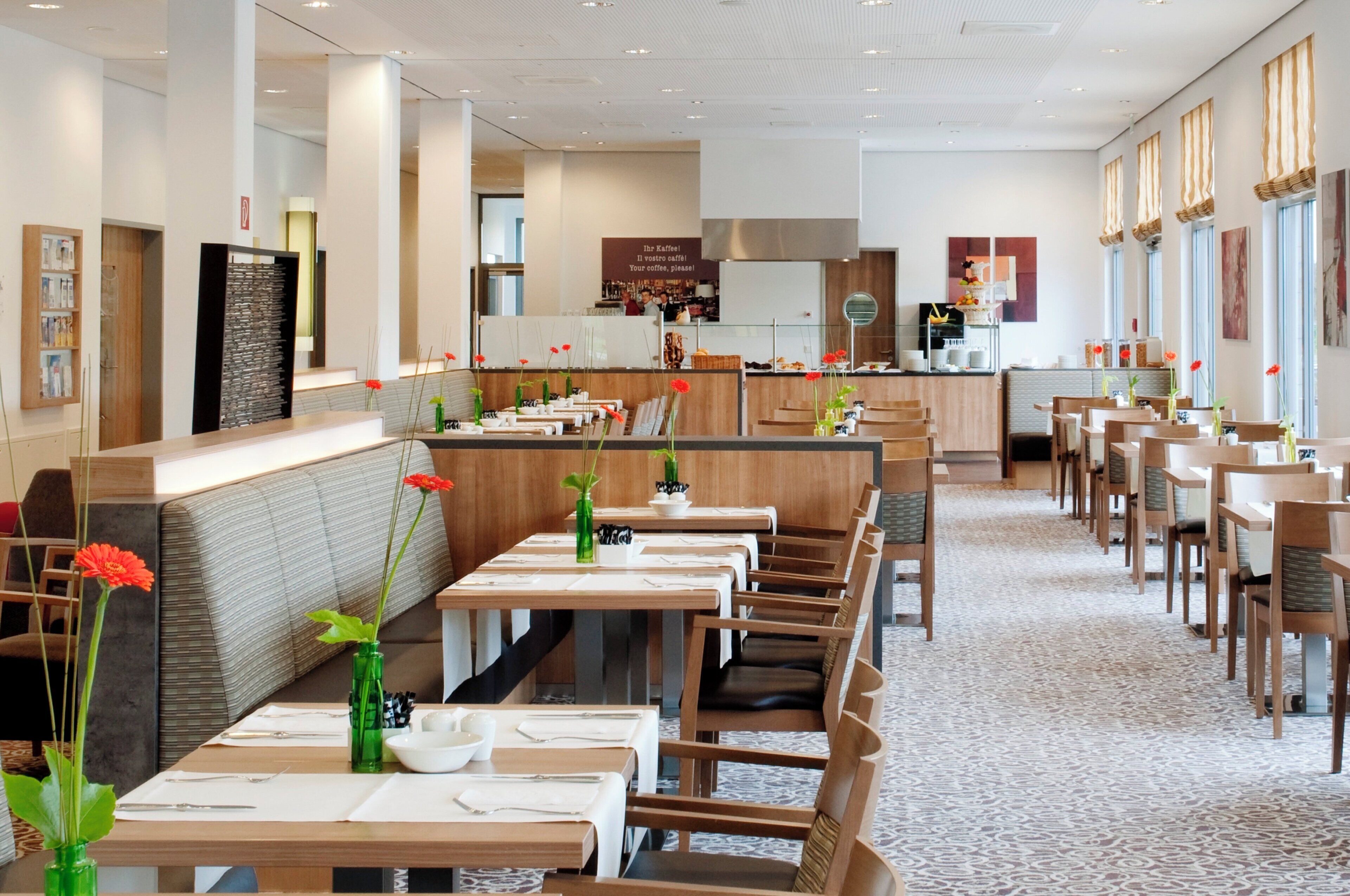 Un restaurante con varias mesas y cabinas, una zona de bar y una estación de café.