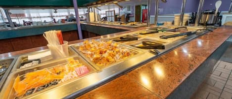 A buffet area with various food items and utensils.
