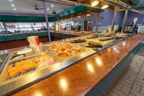 A buffet area with various food items and utensils.