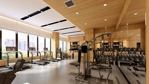 Un gimnasio moderno con cintas de correr, máquinas de pesas y un espejo grande.