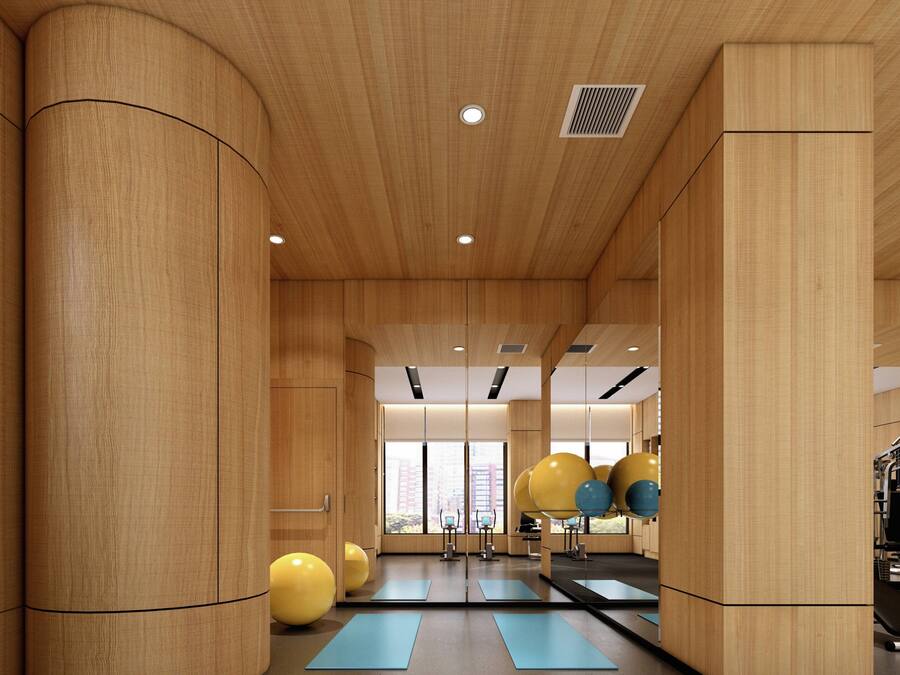 Une salle de sport avec des murs en bois, du matériel d’exercice et de grandes fenêtres.
