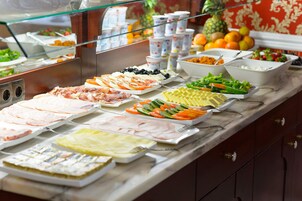 Un buffet con diverse opzioni tra cui carni, formaggi e insalate.