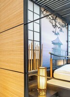 Quarto japonês tradicional com tatames, um painel shoji e vista para uma pagoda através de uma grande janela.