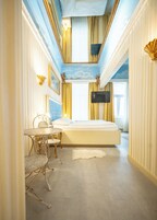 Quarto com uma cama, uma escrivaninha e uma televisão.