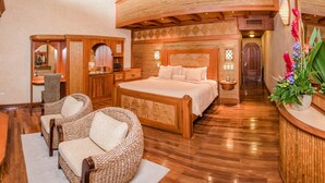 Un dormitorio amplio con una cama grande, muebles de madera y un techo curvo de madera.