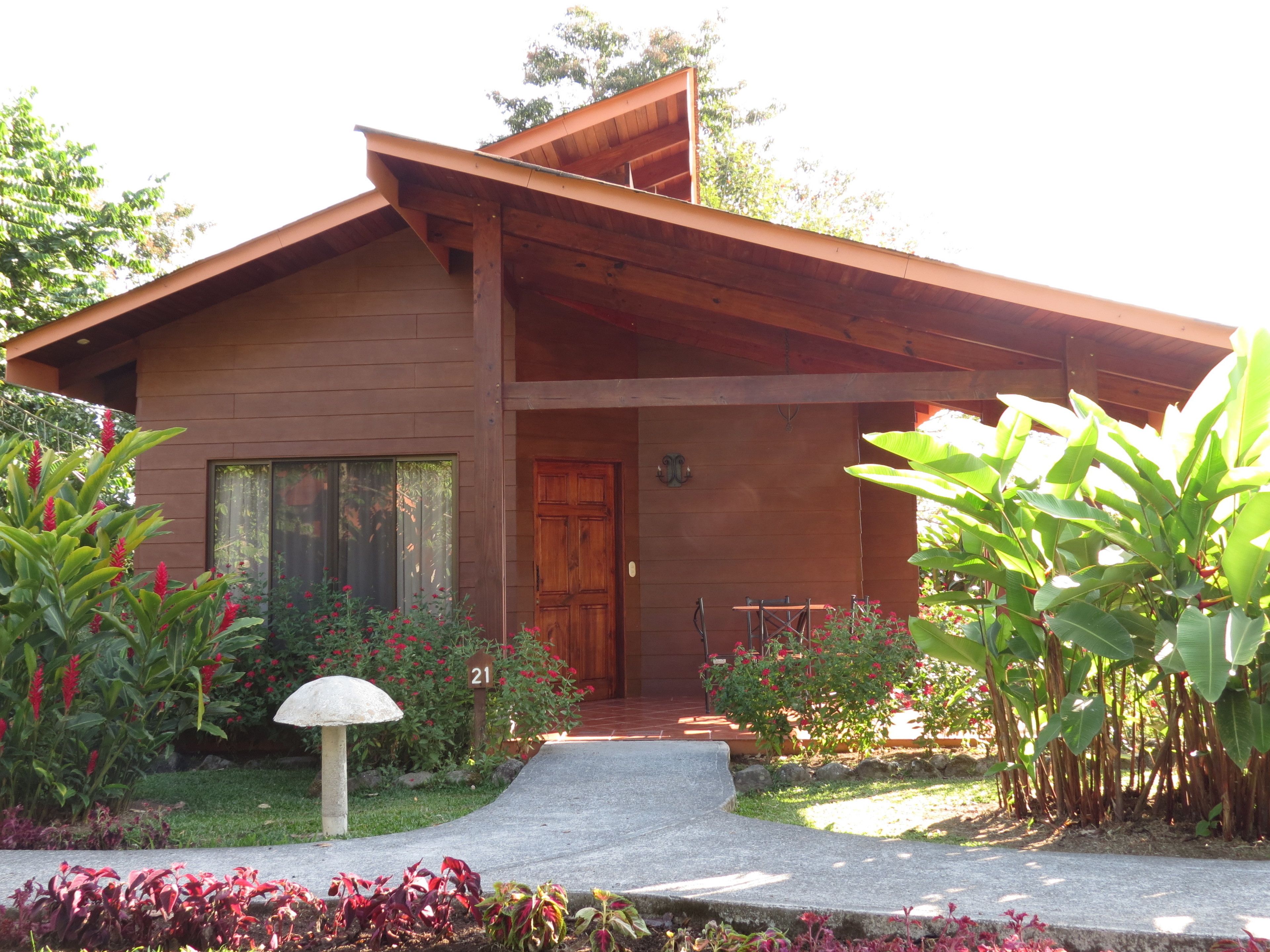 A wooden house with a sloped roof, a front door, and a small porch.