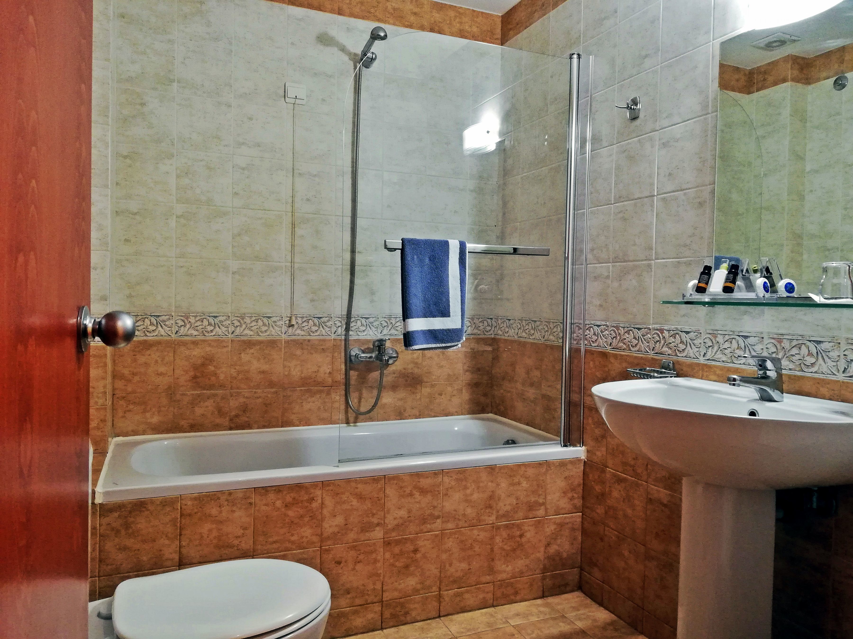 Een badkamer met een bad, een wastafel en een toilet.