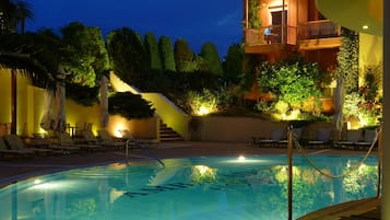 Una piscina al aire libre de temporada, sombrillas