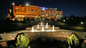 Vista frontal de la propiedad por la tarde o noche