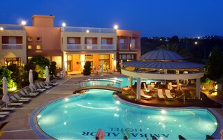 Un hotel con piscina, mobiliario exterior y una zona cubierta.