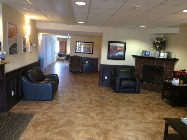 A lobby with a fireplace, seating area, and a reception desk.