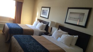 A hotel room with two beds, each with a headboard, a bedside table with a lamp, and framed pictures on the wall. - Comfort Inn & Suites Edson - Yellowhead Highway (Edson)