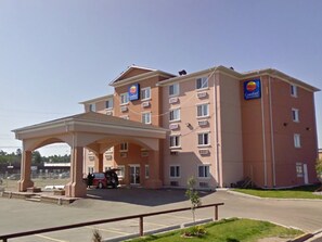 A Comfort Inn hotel with a covered parking area and a small garden. - Comfort Inn And Suites Edson (Edson)