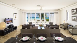 Un salón amplio con un televisor grande, asientos cómodos y un comedor listo para disfrutar de una comida.