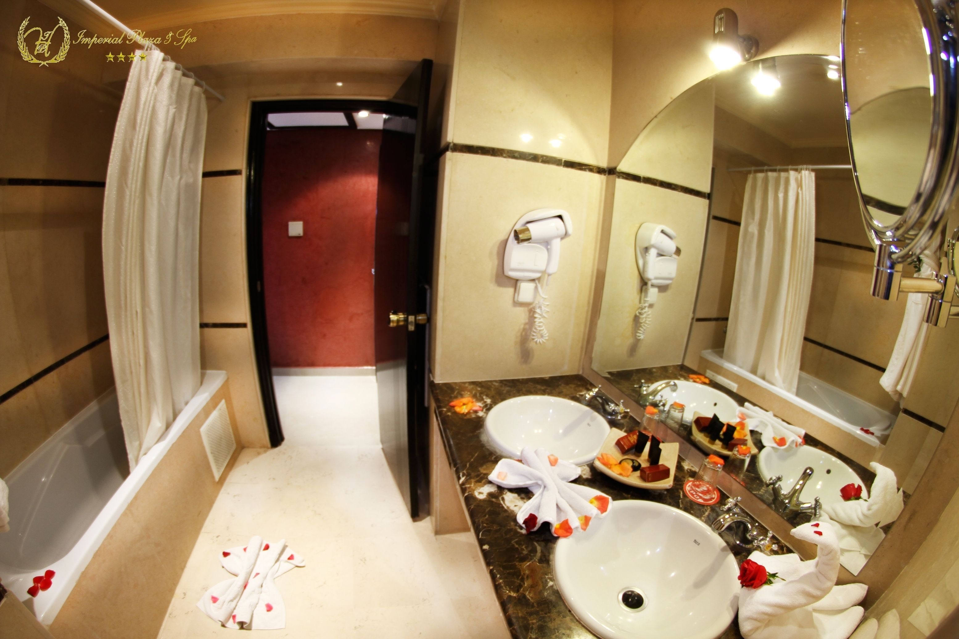 A bathroom with two sinks, a hairdryer, and a mirror.