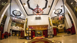 A grand lobby with a red carpet, chandeliers, and red seating areas. - Hotel Imperial Plaza (Marrakech)