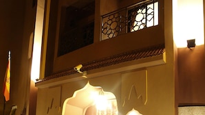 A building entrance with two lion statues, a flag, and a staircase leading to the upper level. - Hotel Imperial Plaza (Marrakech)