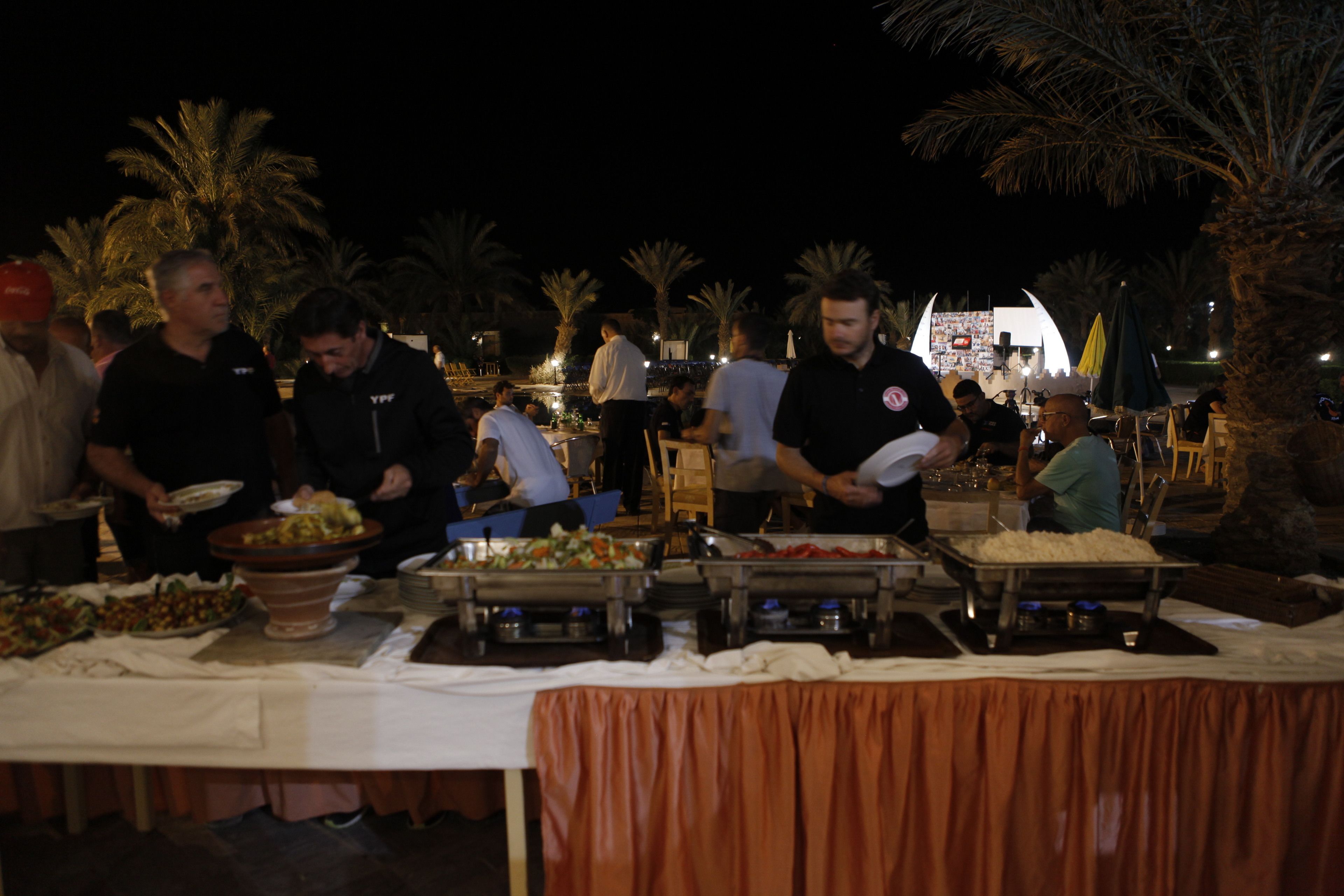 A buffet setup with various food stations and attendees.