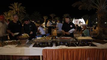 A buffet setup with various food stations and attendees.