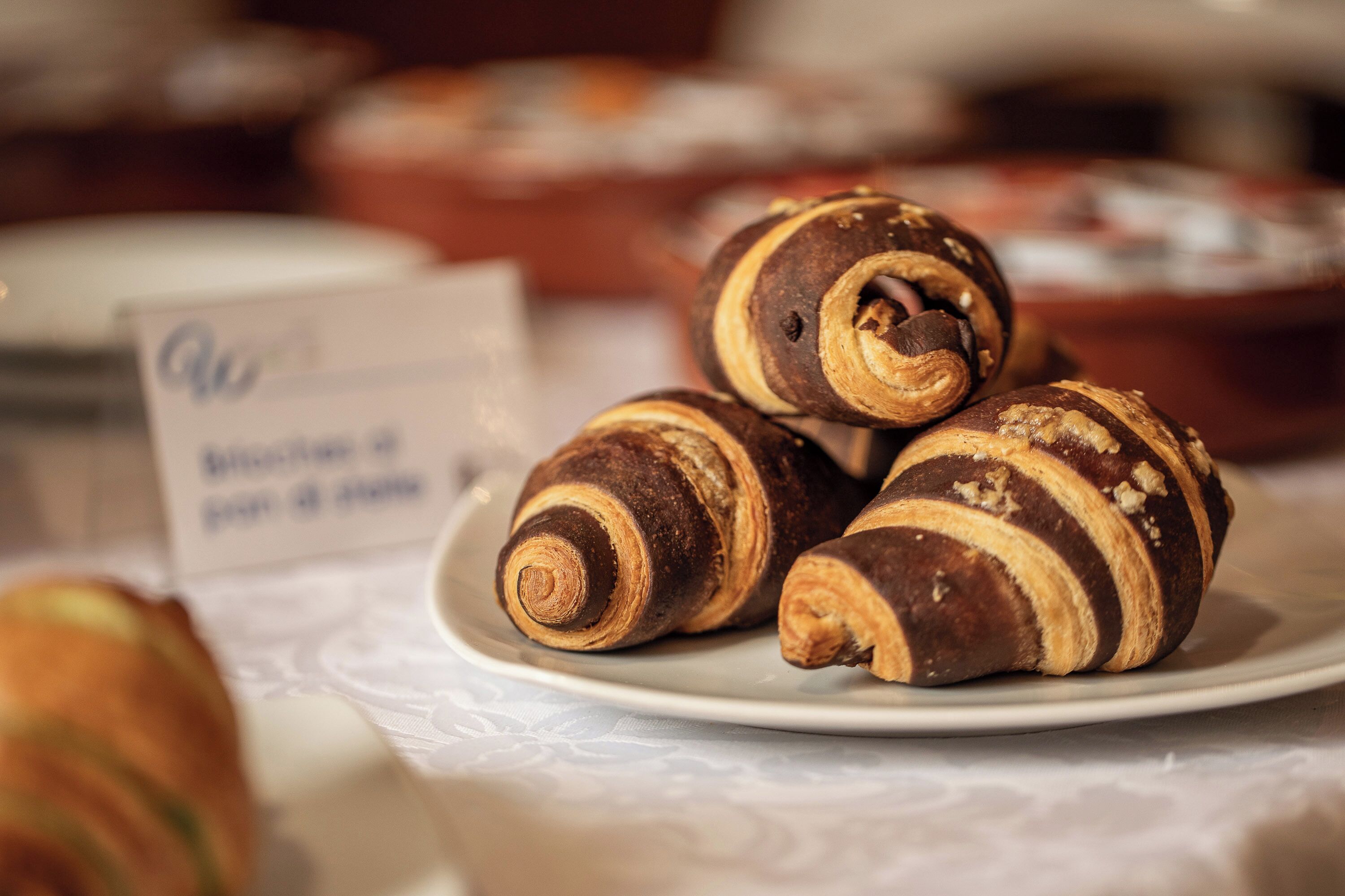 Un piatto con tre croissant al cioccolato su un tavolo.