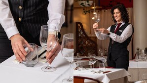 A person pouring wine into a glass, with a dining table set with white tablecloths and wine glasses. - Welcome Hotel Legnano (Legnano)