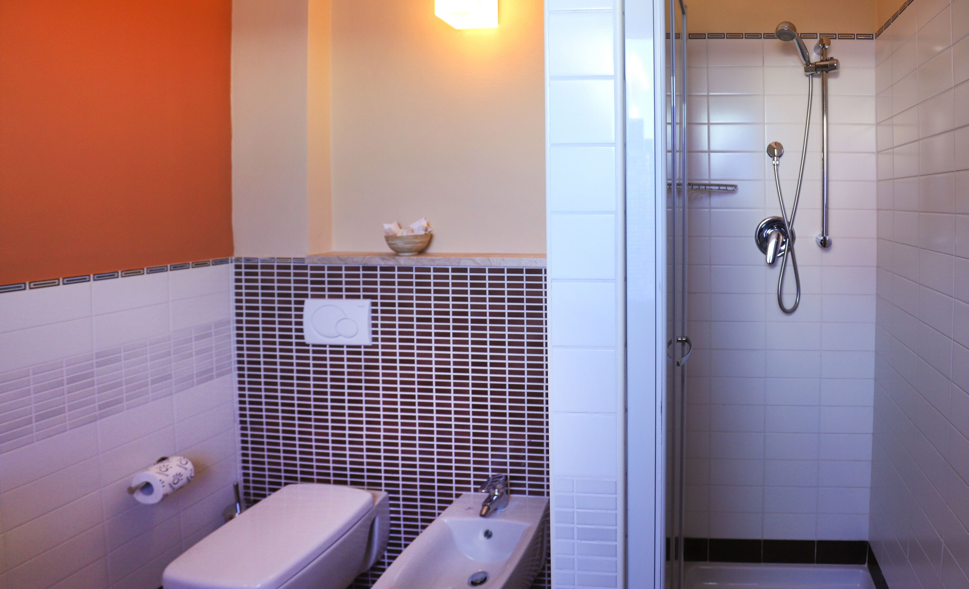 A bathroom with a toilet, sink, and shower.