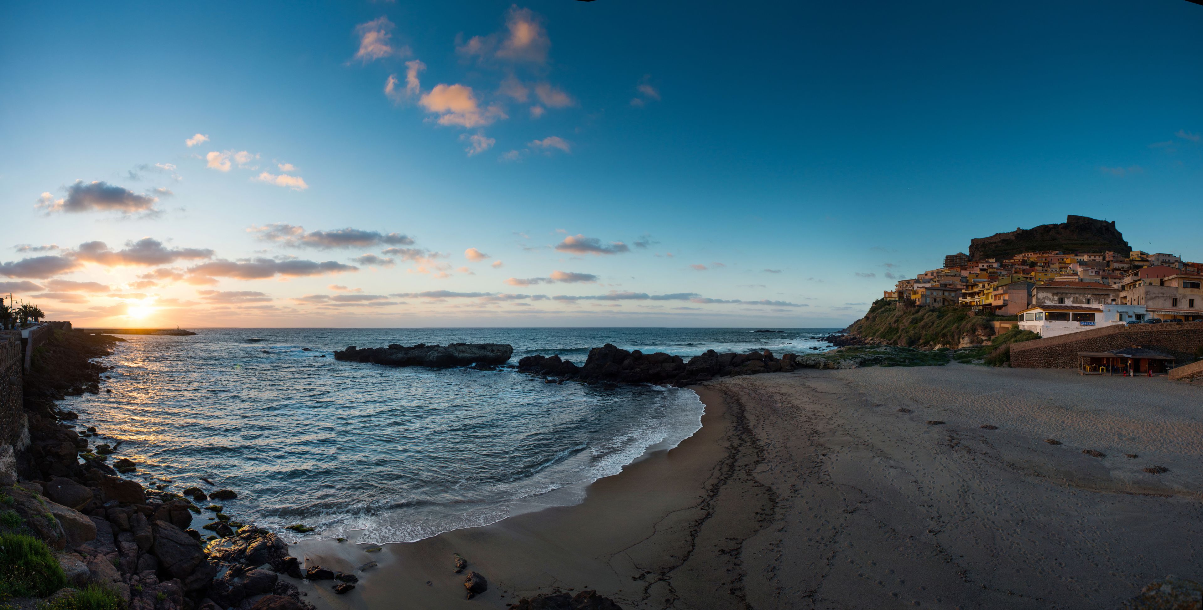 A coastal town with a prominent hill and a beach.