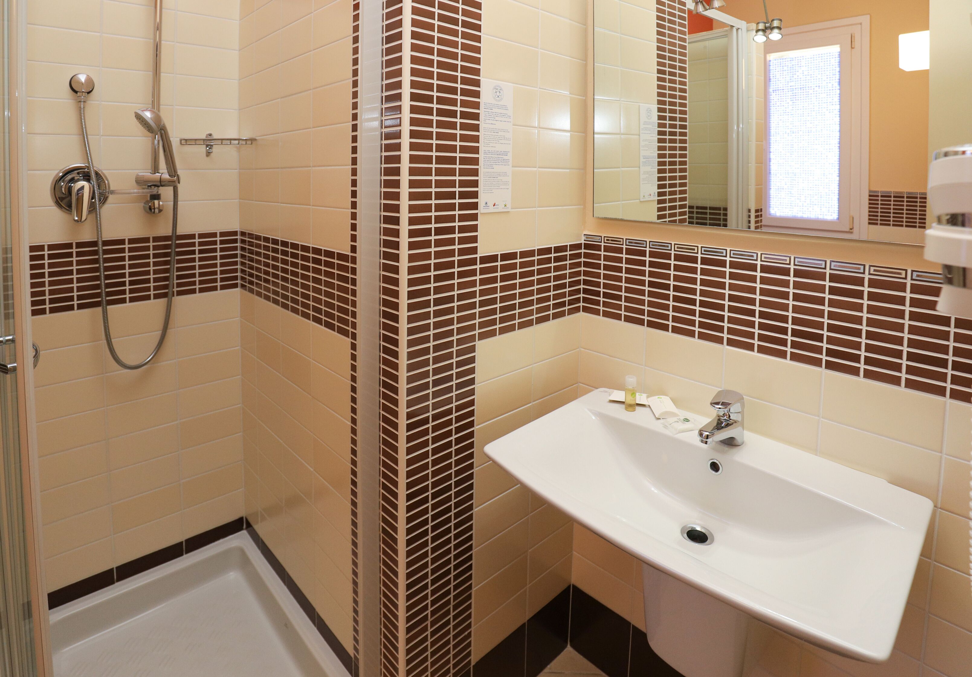 Un bany amb dutxa, un lavabo i un mirall.