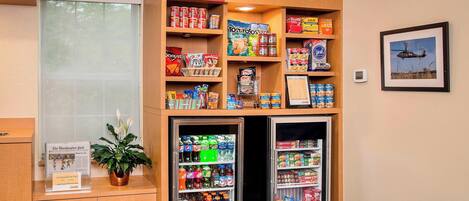 A vending area with snacks, drinks, and a newspaper display.