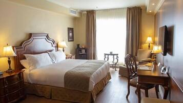 Una habitación de hotel con cama, mesitas de noche, un escritorio y una silla.