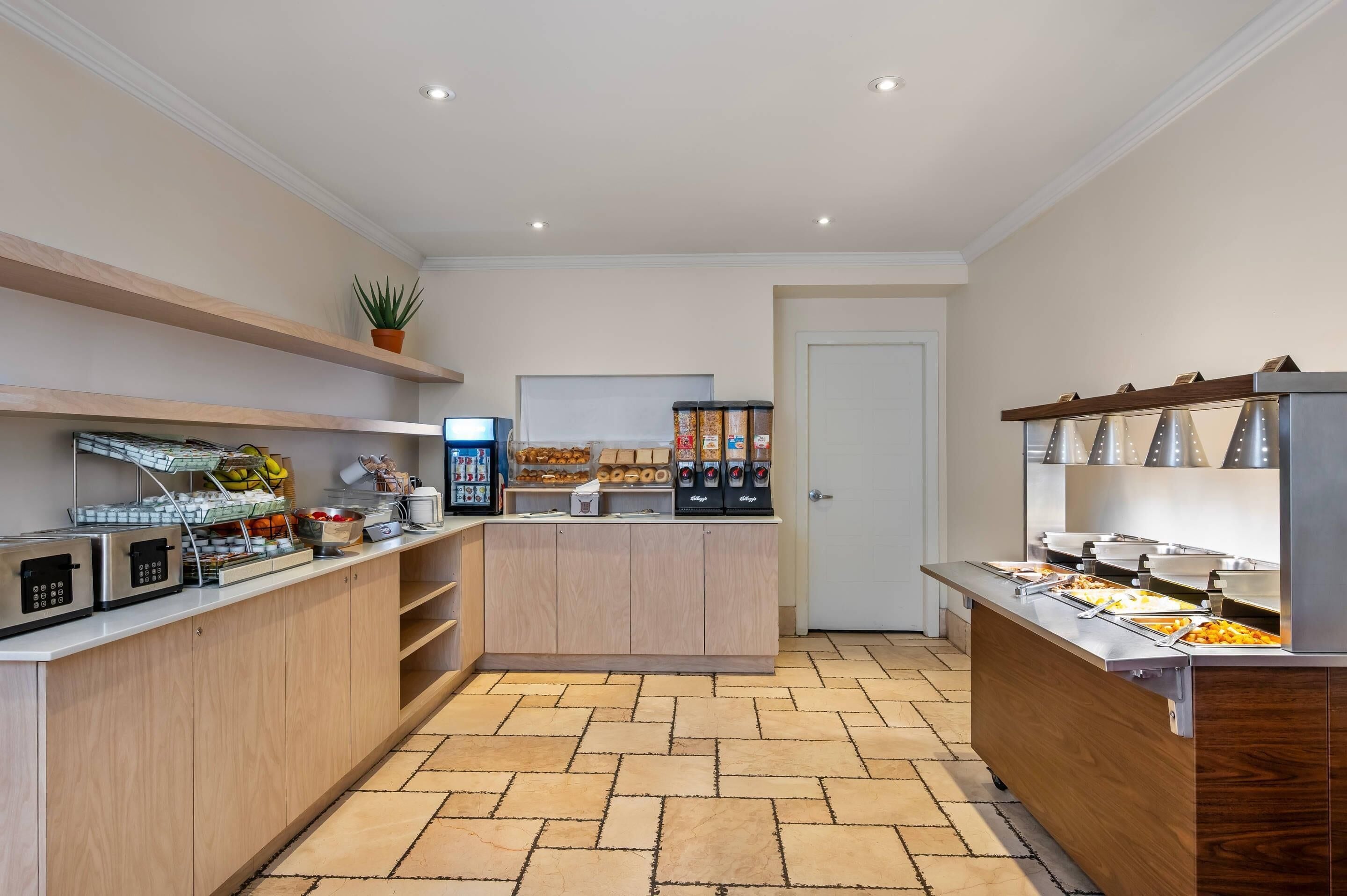 Una cocina moderna con electrodomésticos integrados, un espacio para café y diversos alimentos.