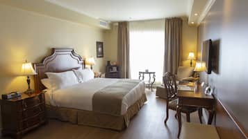 A hotel room with a large bed, bedside tables, a desk, and a chair.