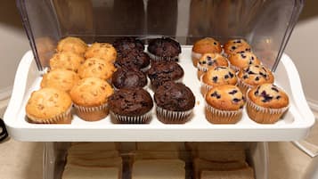 Vitrina de forneria amb diferents muffins i pa.