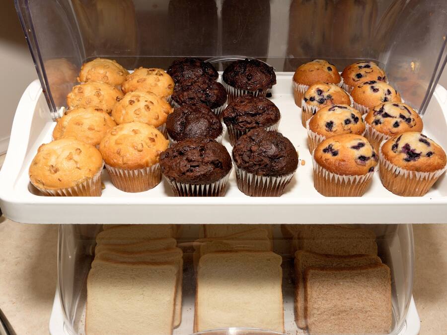 Vitrina de forneria amb diferents muffins i pa.