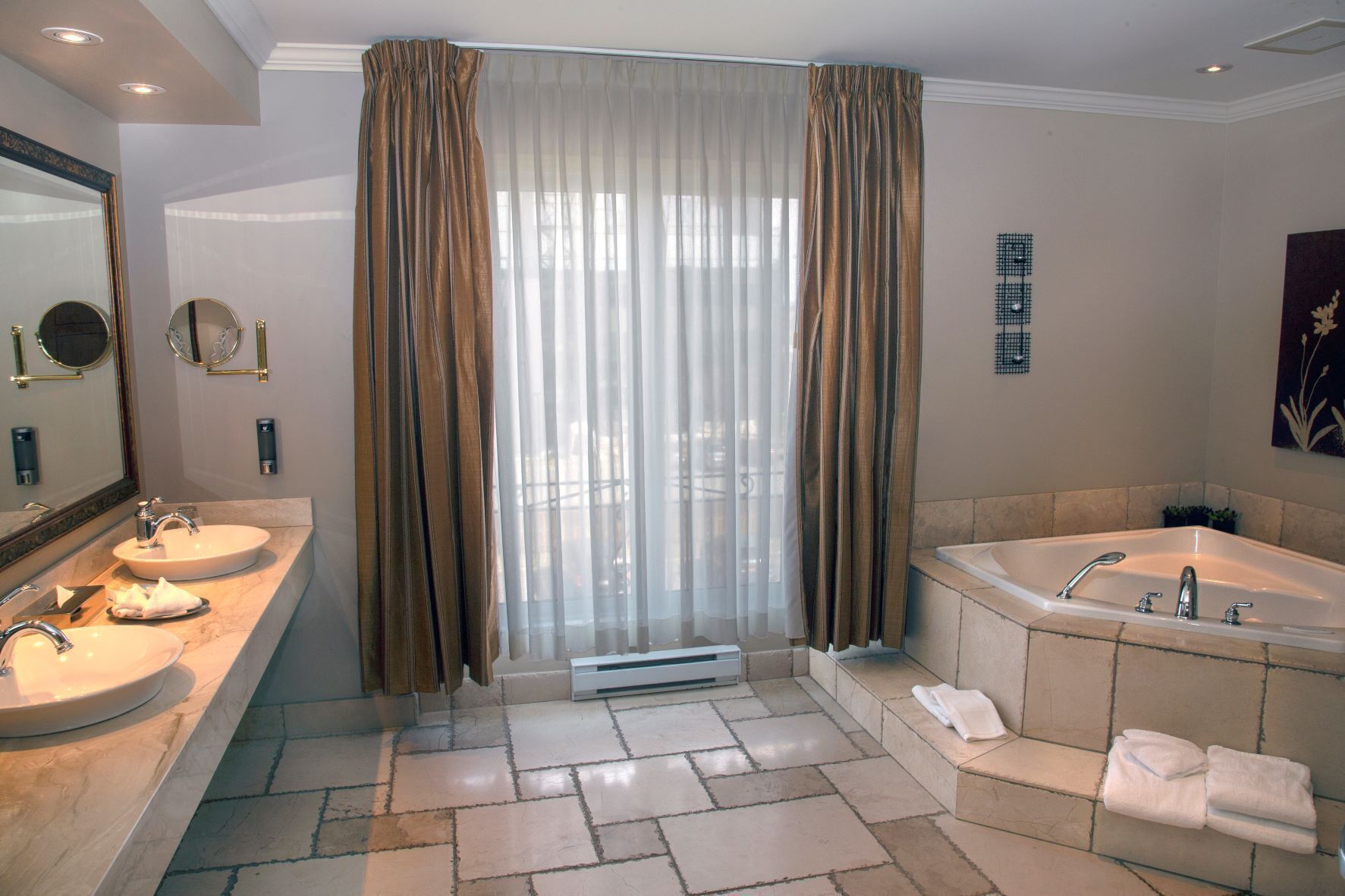 A bathroom with two sinks, a bathtub, and a large mirror.